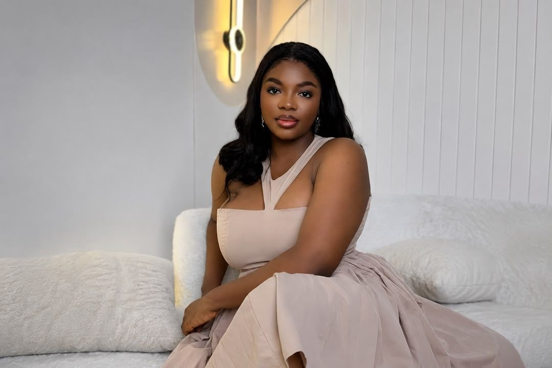 The founder and CEO of Mo Icons Agency seated in a soft blush gown in a bright studio