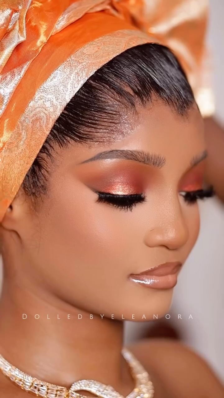 Gold gele and coral bronze beauty look from the Mo Icons Agency feed